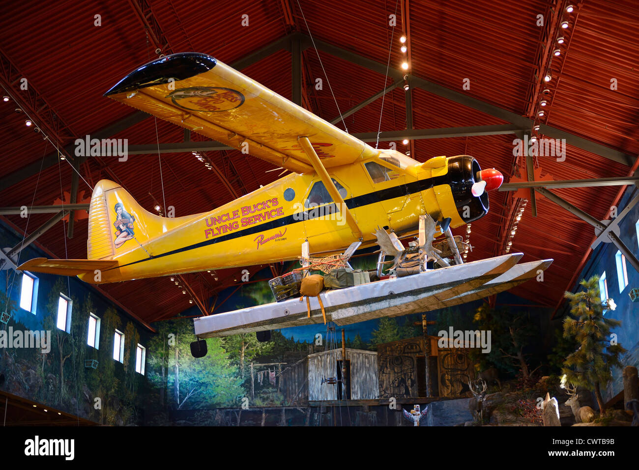 Yellow Beaver float plane hanging in the rafters of an outfitters store Stock Photo