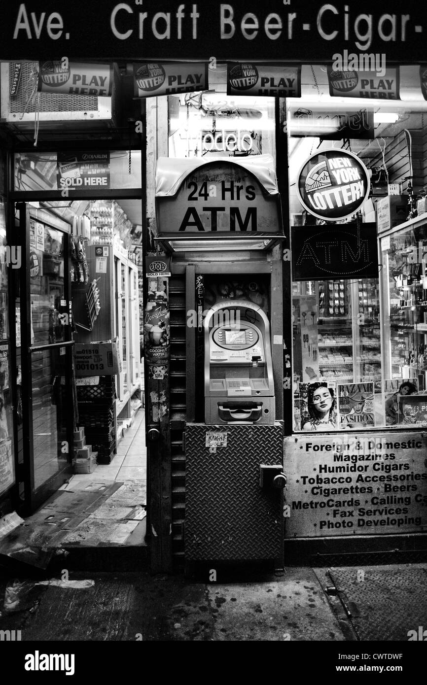 black and white photo of atm machine in front of a little grocery store Stock Photo