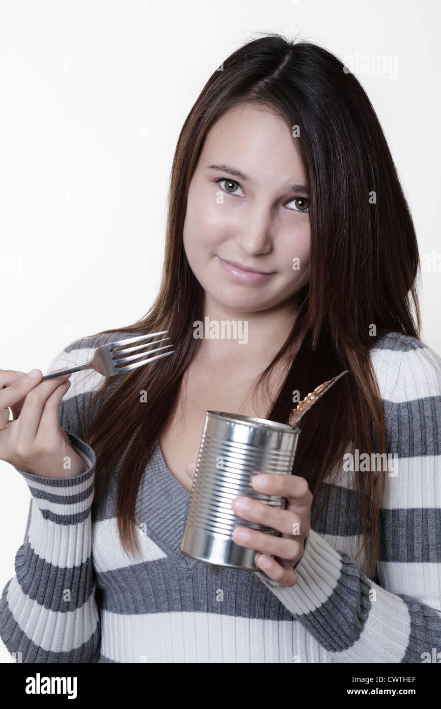 young woman eating cold bake beans from the tin Stock Photo Alamy