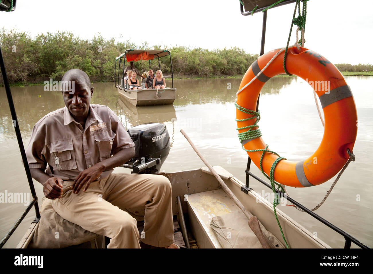 The guide prepares for a boat safari on Lake Manze, lake Manze camp, the Selous Tanzania Africa Stock Photo