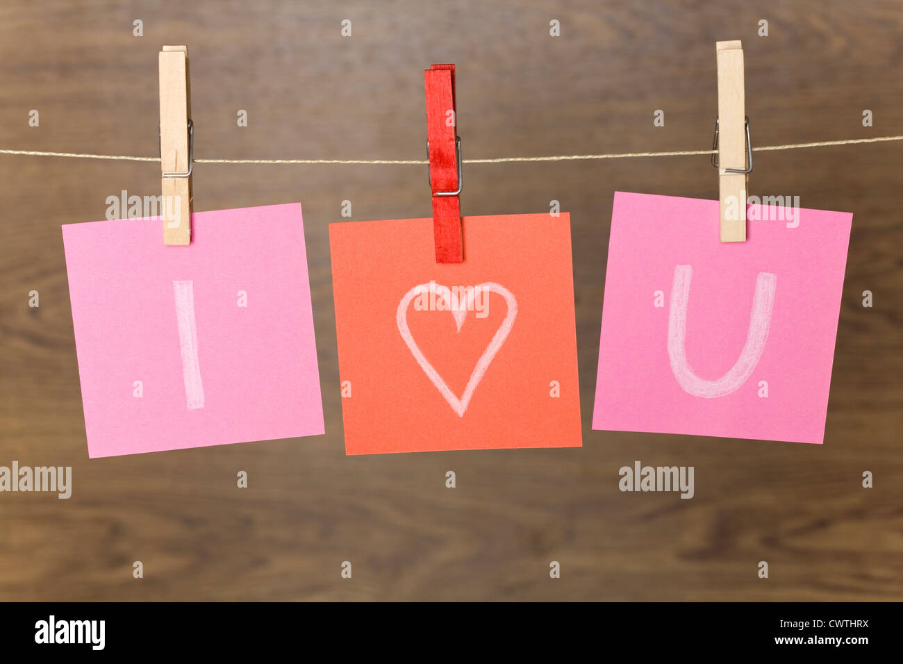 Three slips of paper  with declaration of love hanging on clothesline Stock Photo