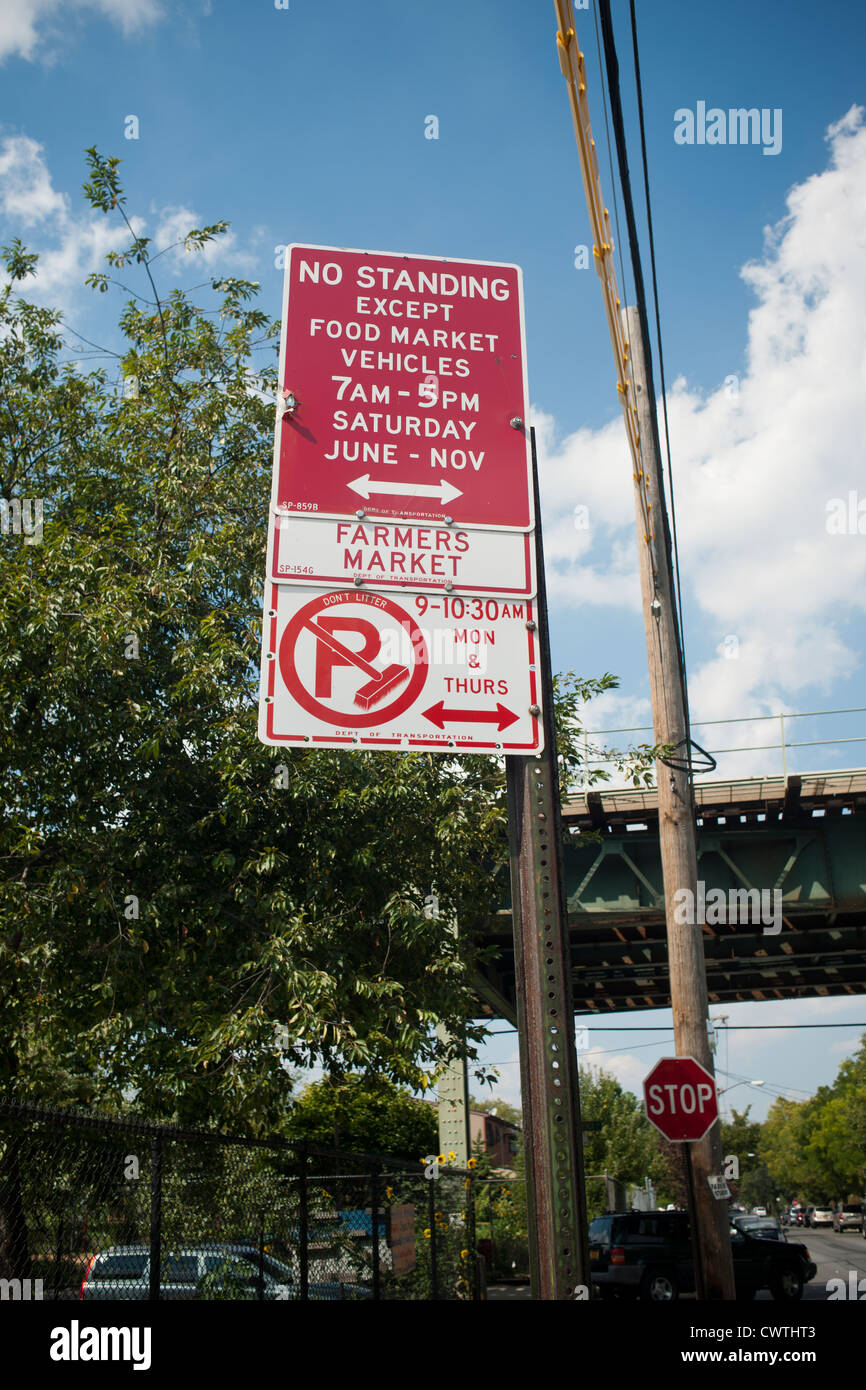 No parking sign outside a farmers market in Brooklyn in New York in the shadow of the elevated subway train Stock Photo