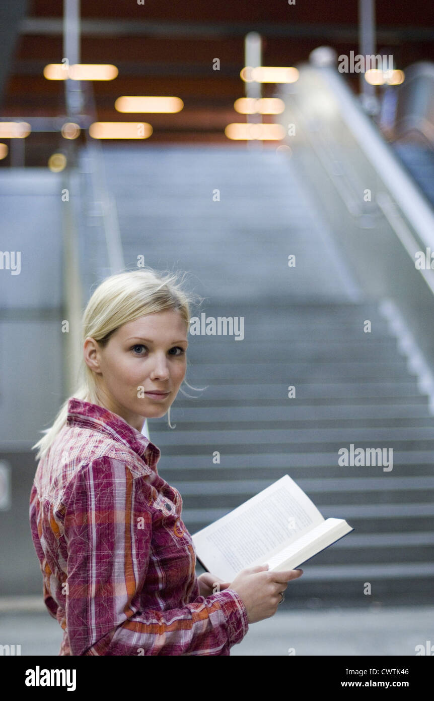 Smiling young woman holding book Stock Photo - Alamy