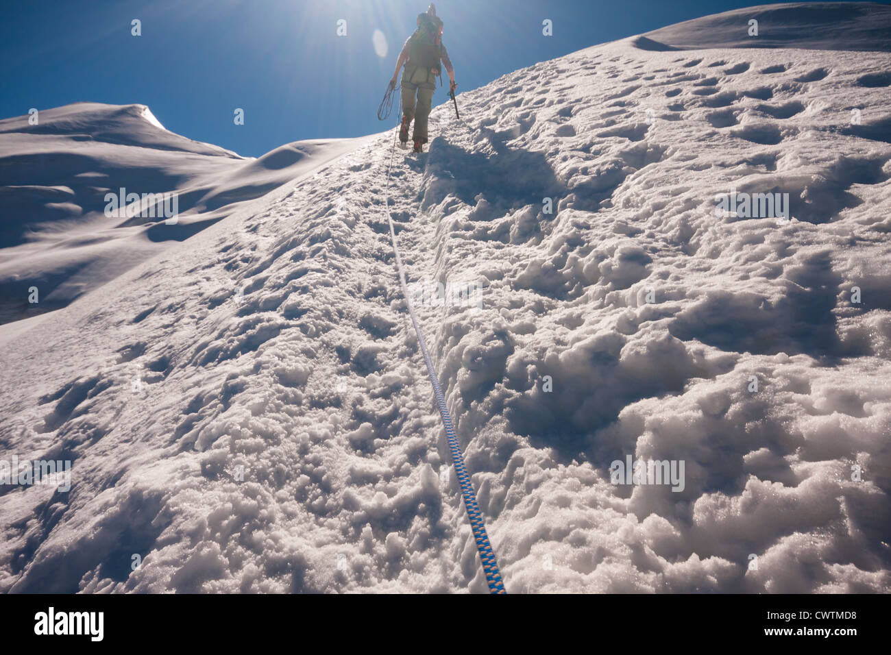 A mountaineer climbing the ridge to the summit of Weissmies in the Alps. Saas Grund Switzerland. Stock Photo