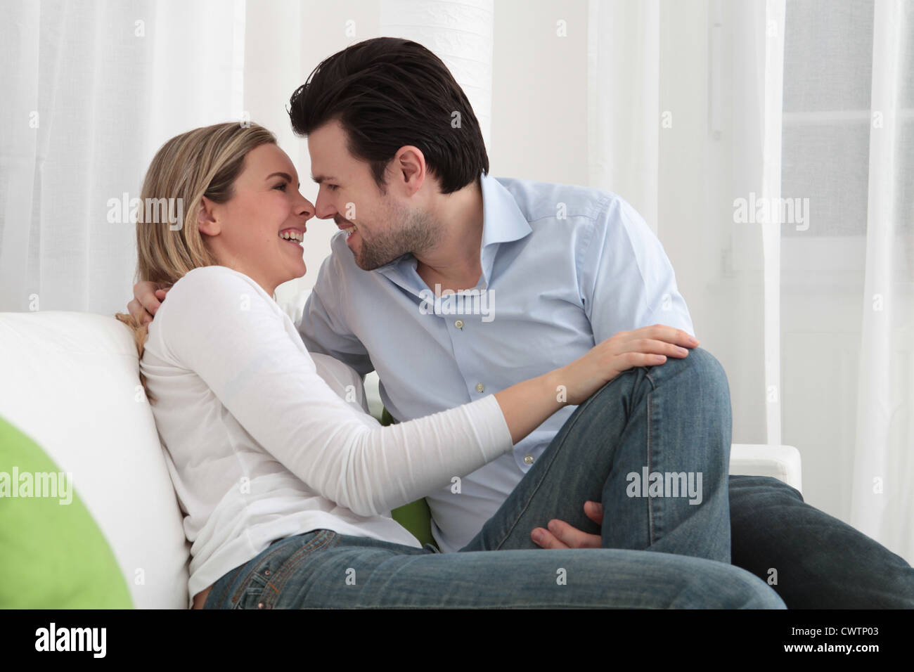 Happy couple hugging on couch Stock Photo Alamy