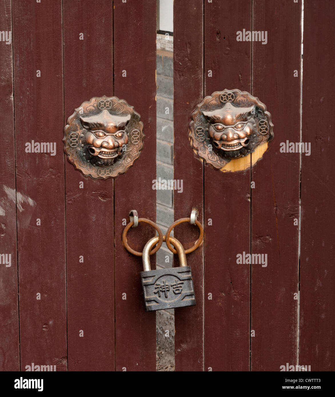 Two Chinese Lion Heads Decorate A Old Locked Door In The City Of