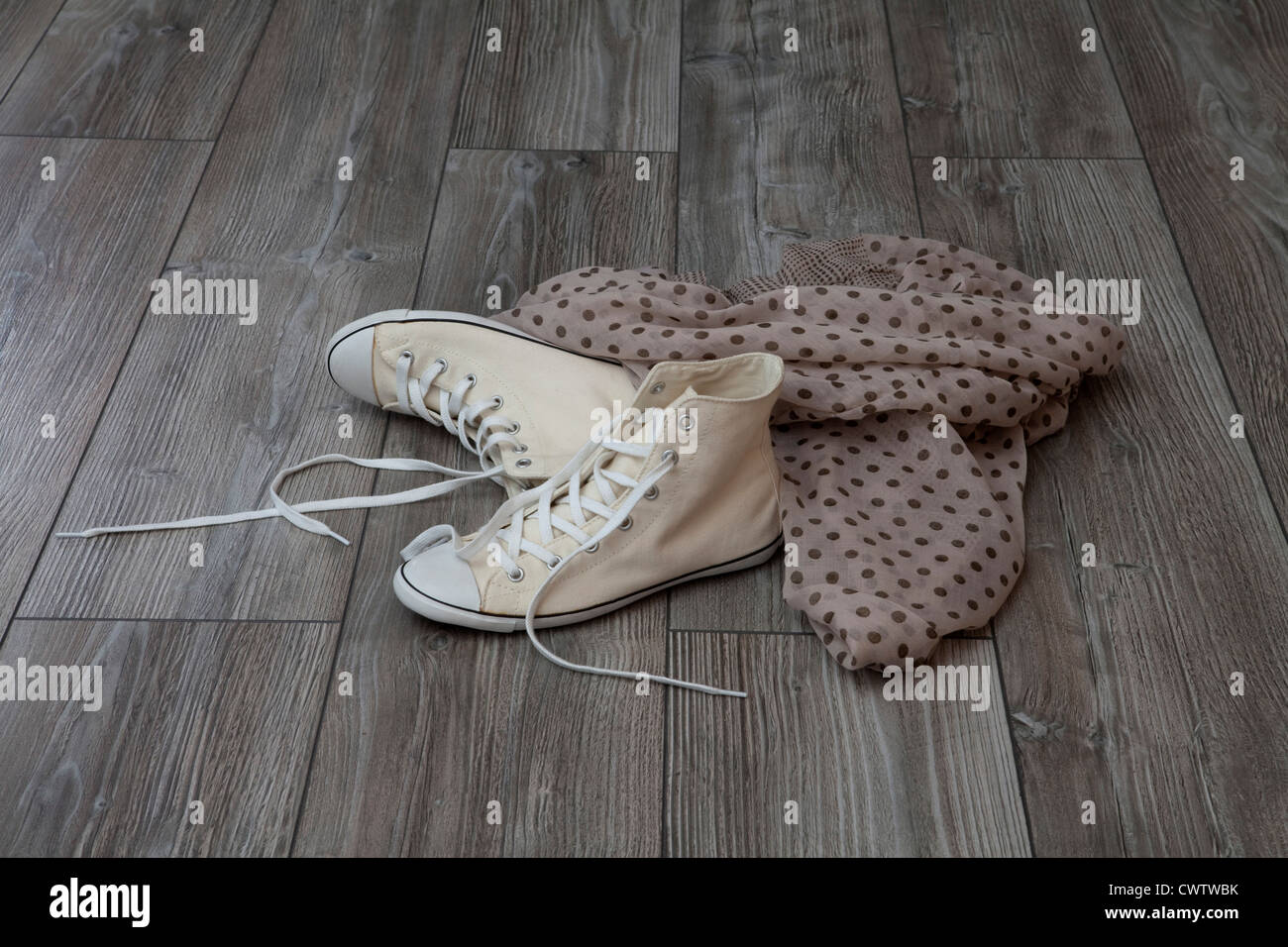Pair of sneakers and cloth on wooden floor Stock Photo - Alamy