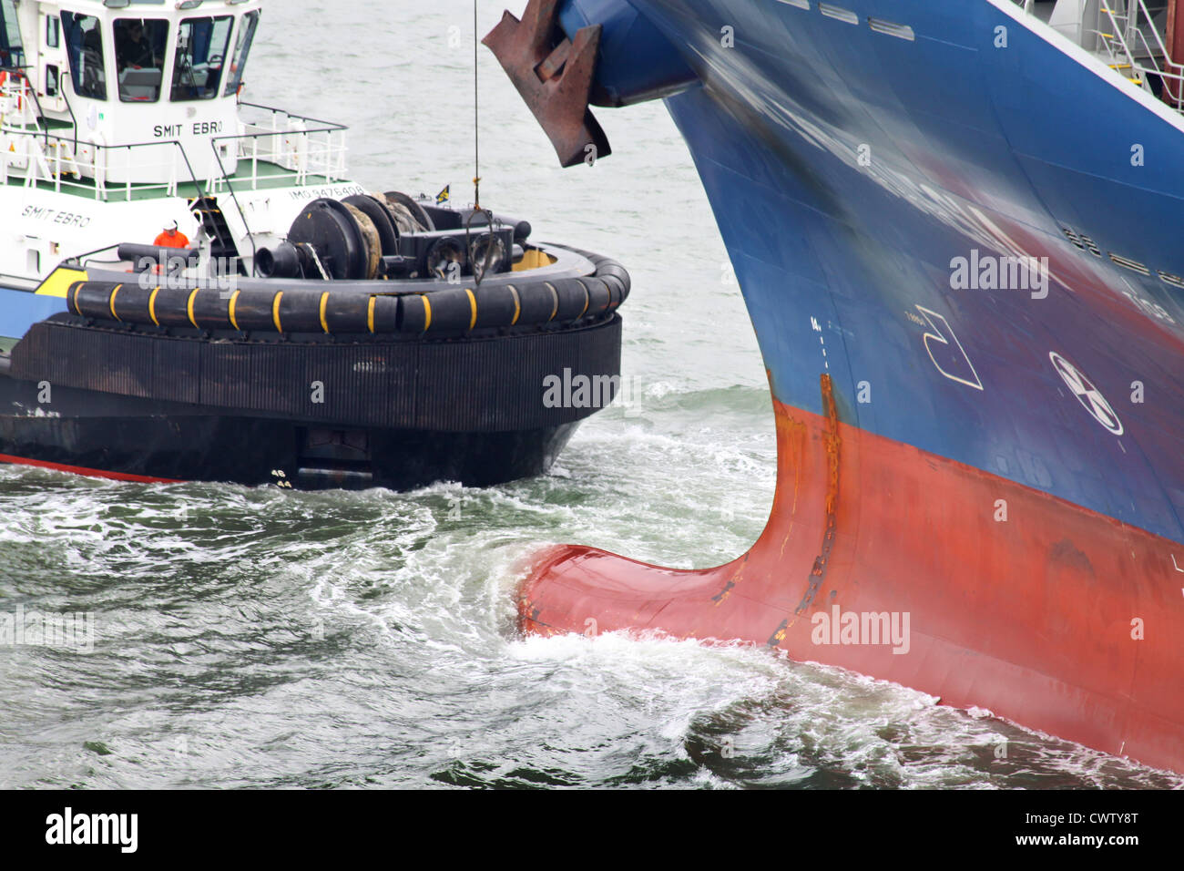 Harbour tug and bow of large containership, Port of Rotterdam Stock Photo
