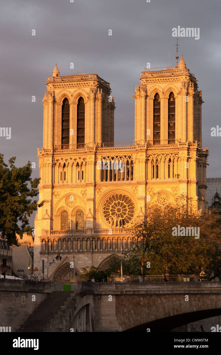 The last rays of the sun catch the edifice of the Notre Dame Cathedral in Paris. Stock Photo