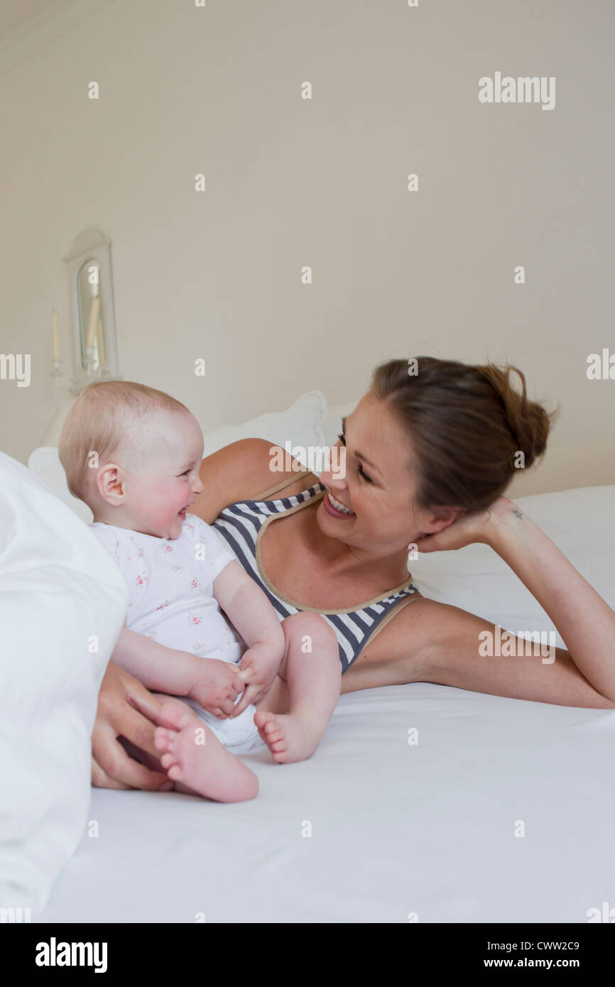 Mother and baby laying on bed Stock Photo Alamy
