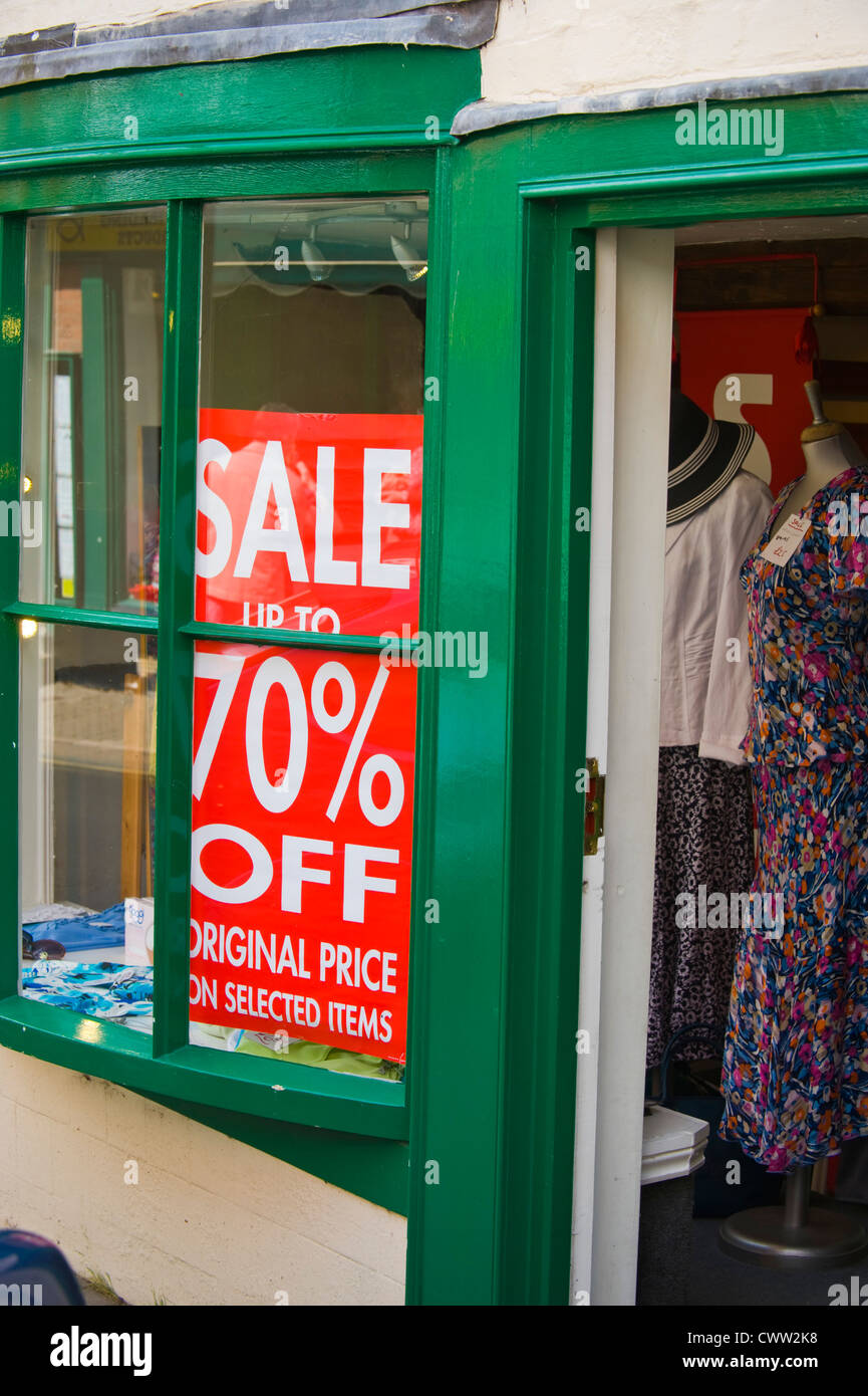 70 off sale poster in window of ladies clothes shop on high street in