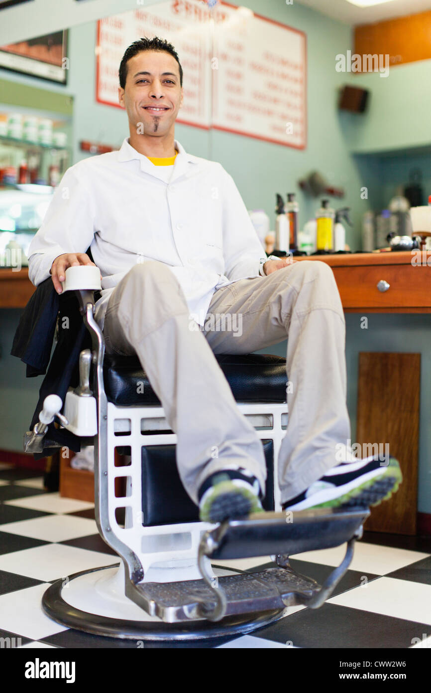 Barber sitting in chair in shop Stock Photo - Alamy