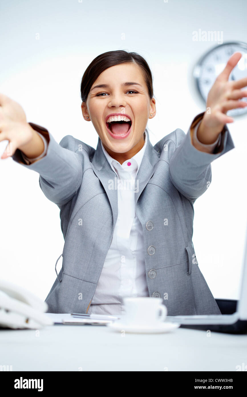 Image of young businesswoman shouting in gladness with raised arms Stock Photo