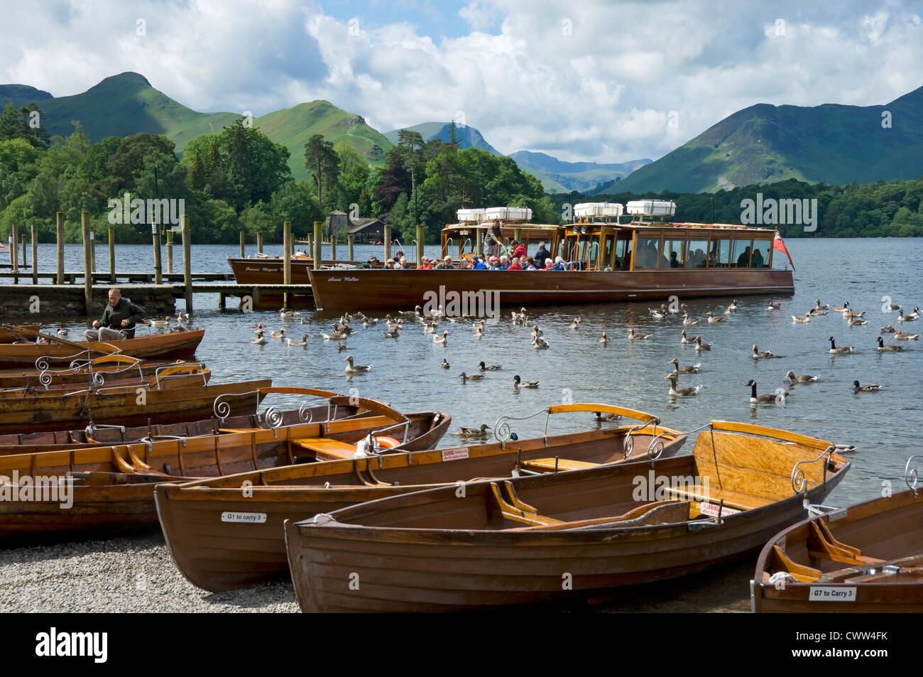 People tourists visitors on launch boat rowing boats on Derwentwater