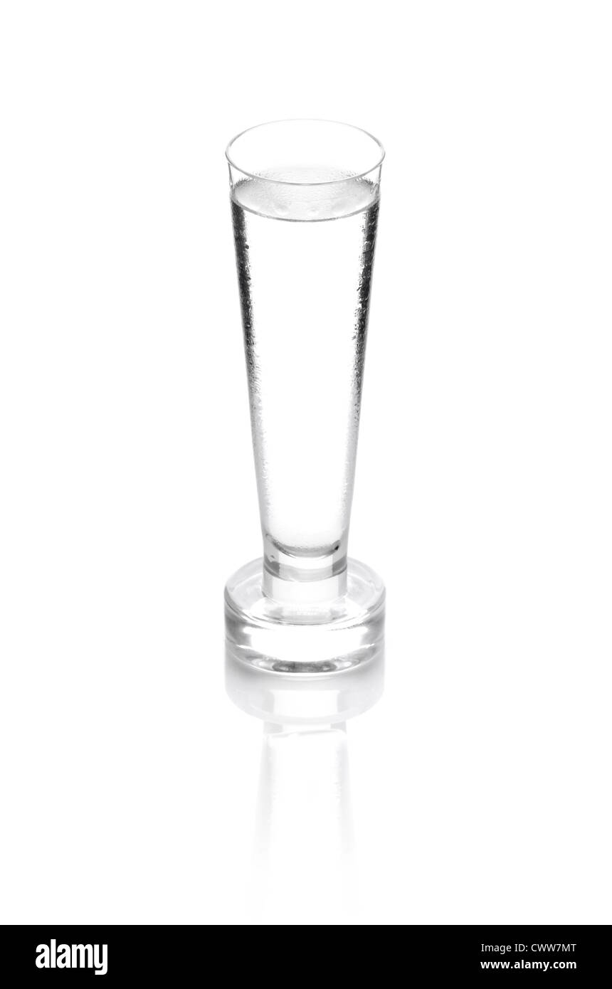 shot glass filled with clear cold alcohol isolated on white Stock Photo