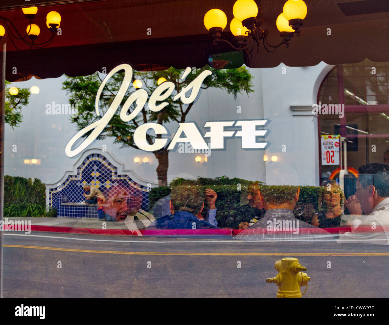 Restaurant patrons viewed through a window of Joe's Café in "Santa Barbara", California Stock