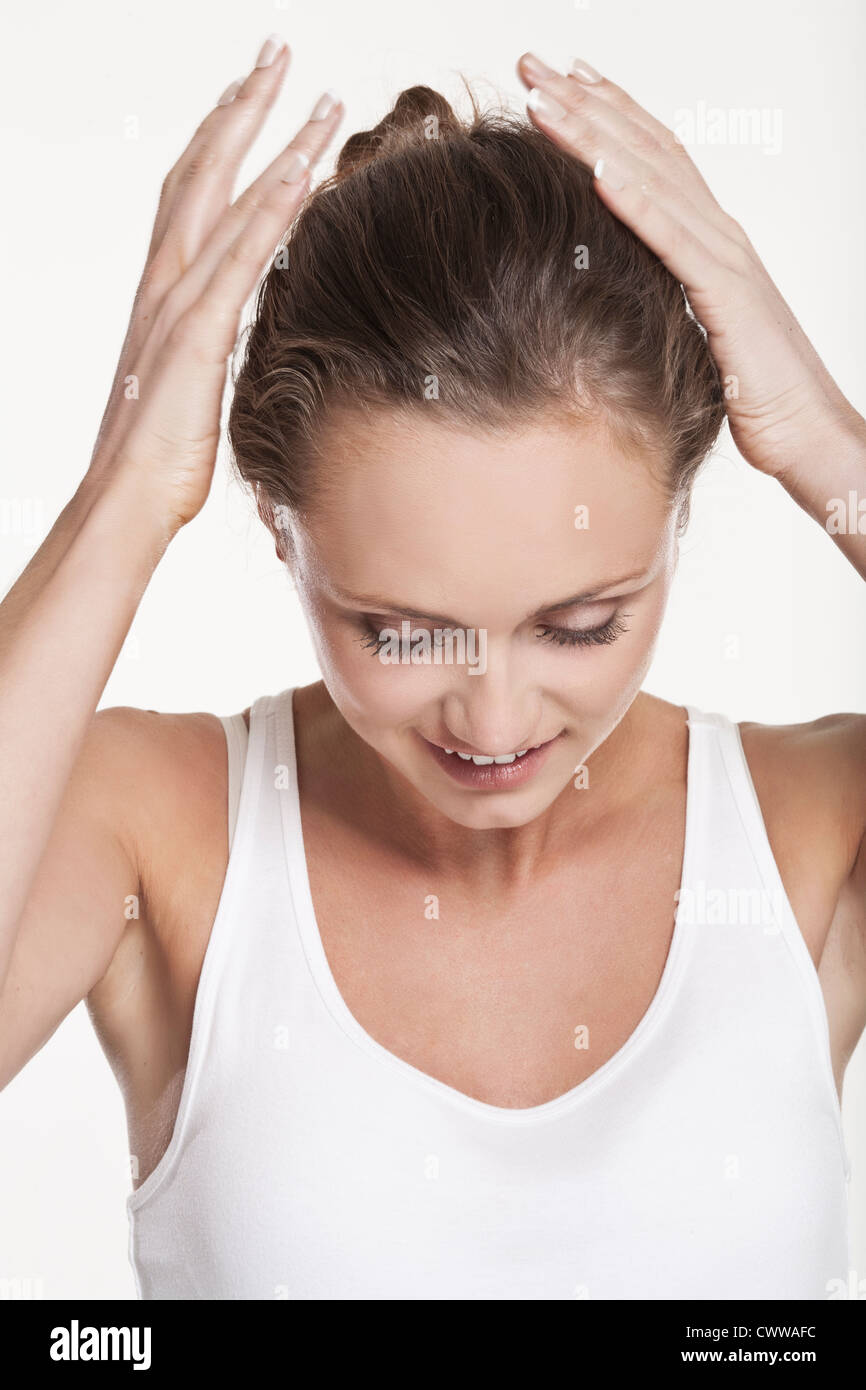 Smiling woman pulling back her hair Stock Photo