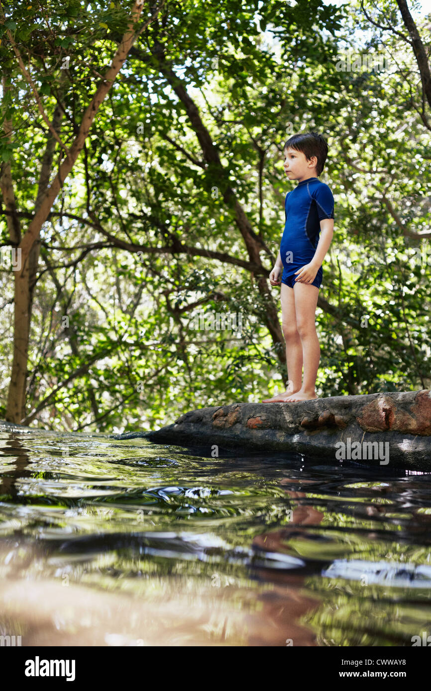 Boy standing by river in forest Stock Photo - Alamy