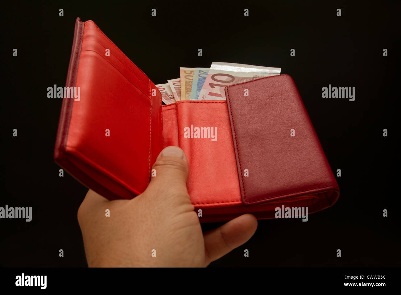 Handing someone a red wallet with Euro  bank notes Stock Photo