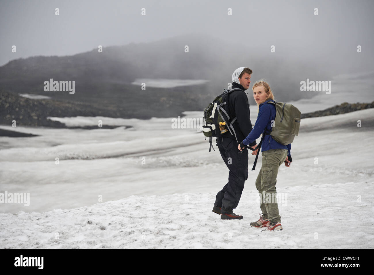 Hikers walking in snowy landscape Stock Photo