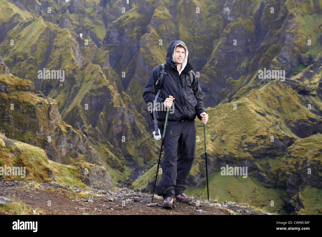 Hiker standing on rocky hillside Stock Photo