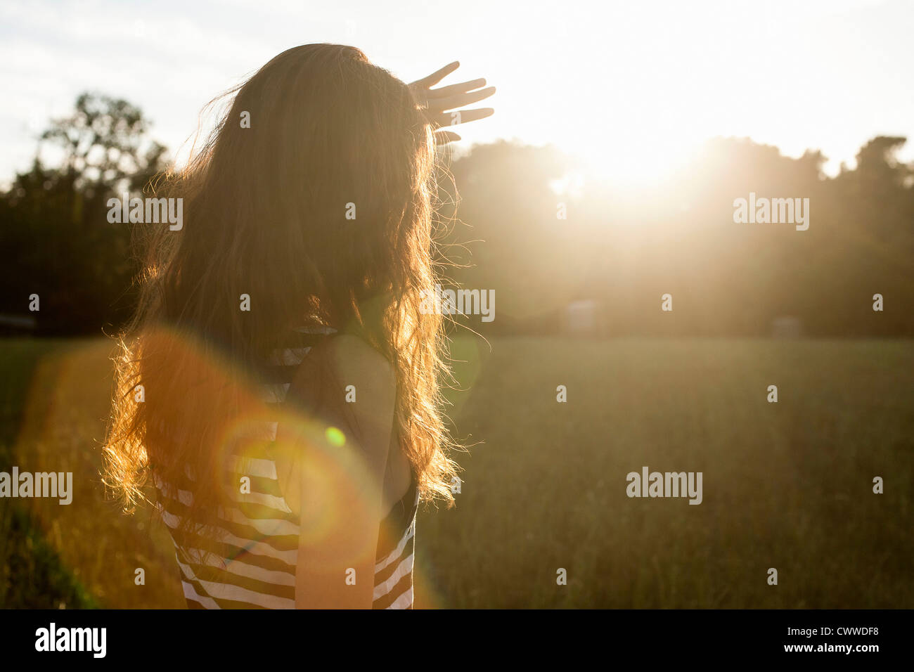 Woman shielding her eyes from sun Stock Photo