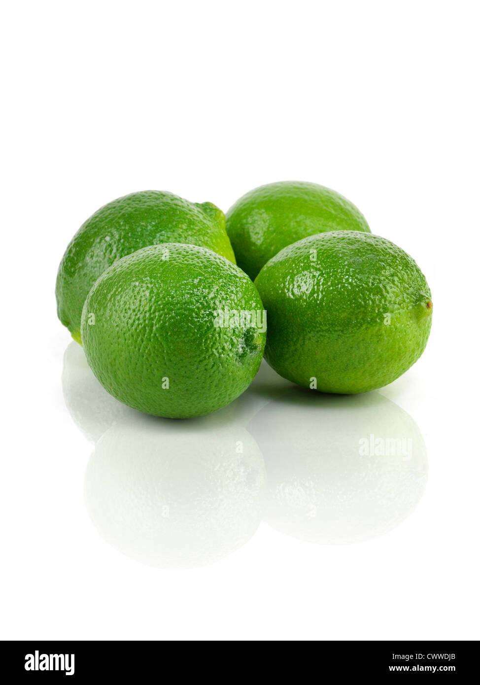 four green limes on reflective table Stock Photo