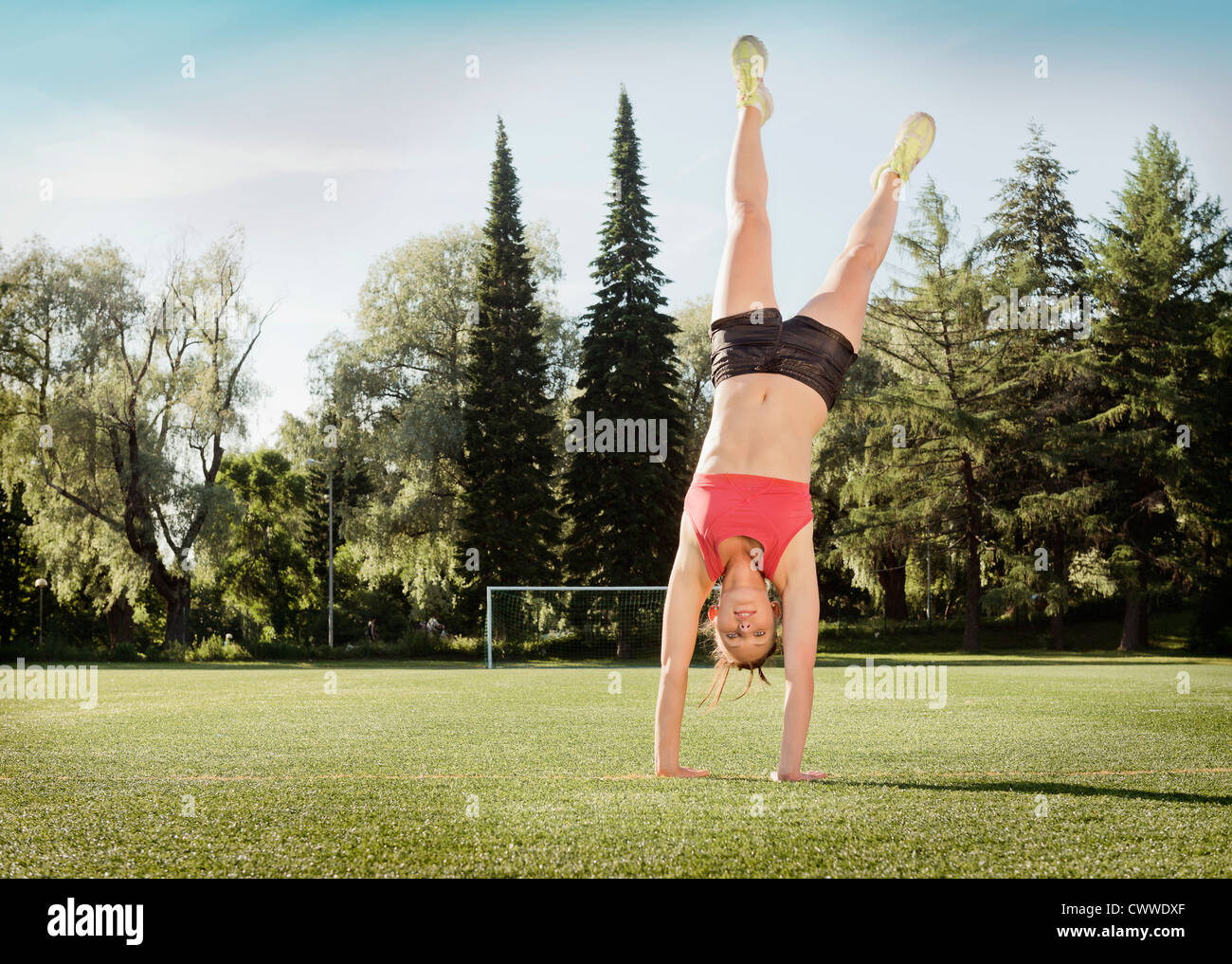 Woman doing cartwheel in park Stock Photo