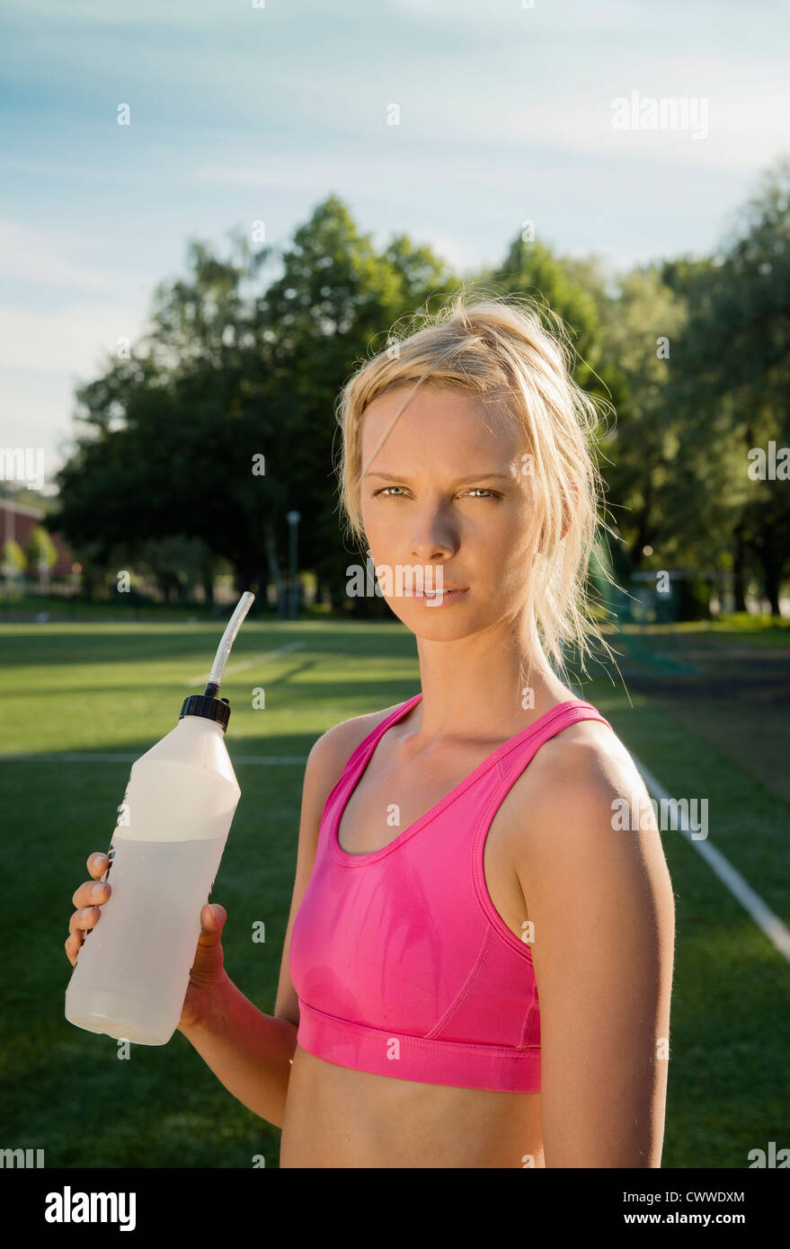 Runner drinking water in park Stock Photo