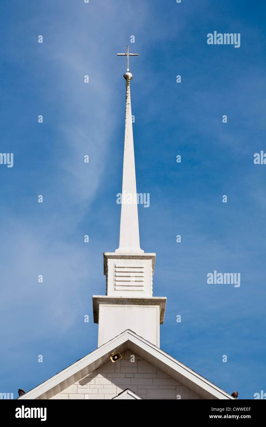 White steeple and cross against a blue sky at Maranatha Baptist Church in Ocala, Florida Stock Photo