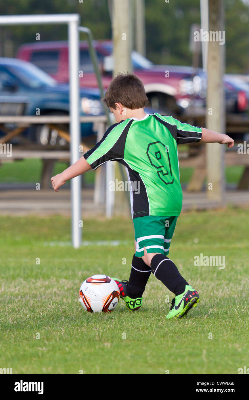 Young boy kicking soccer ball towards goal Stock Photo