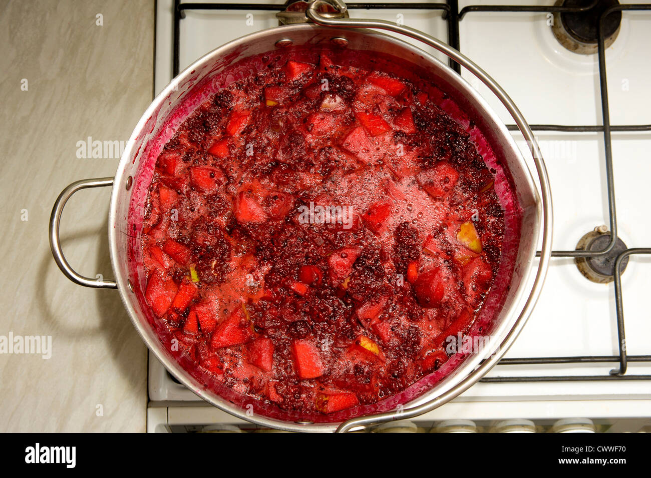 Jam making. Brambles and Apples boiling in Maslin Pan on home cooker Stock Photo
