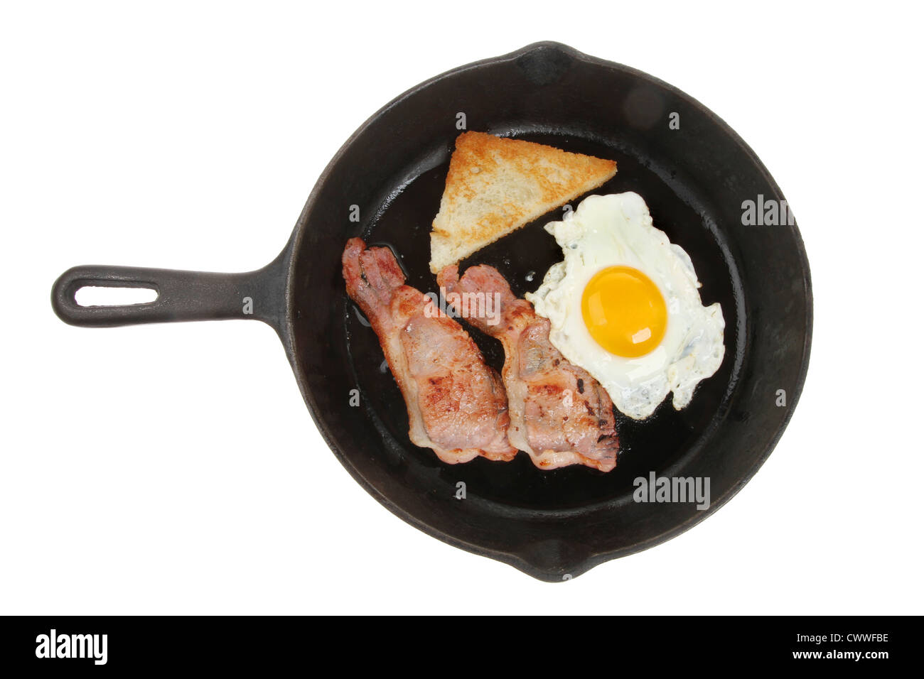 Individual fried breakfast of egg, bacon and fried bread in a pan isolated against white Stock Photo