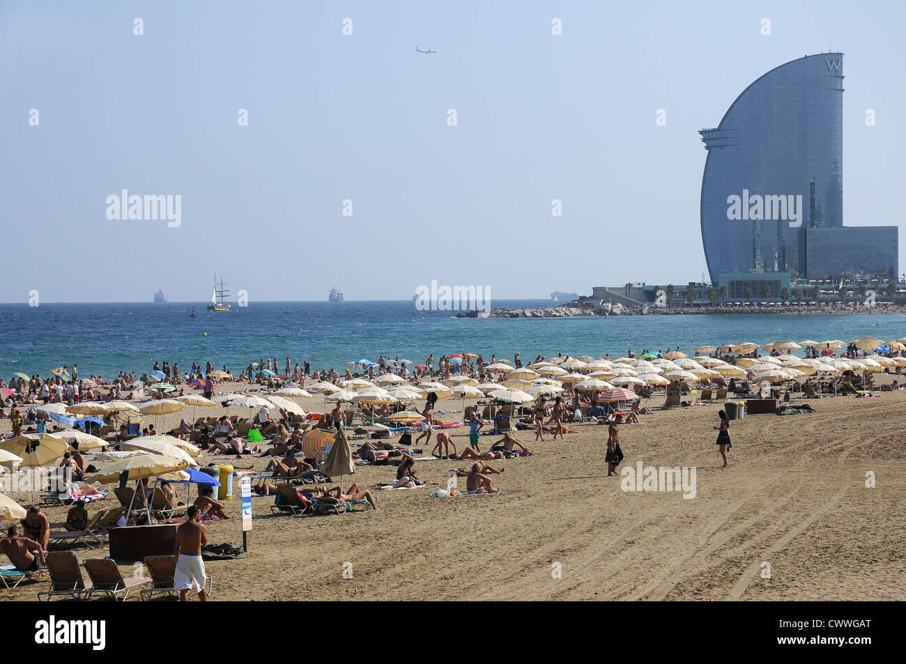 Barcelona beach sunbathers umbrellas Hotel W vela Stock Photo Alamy
