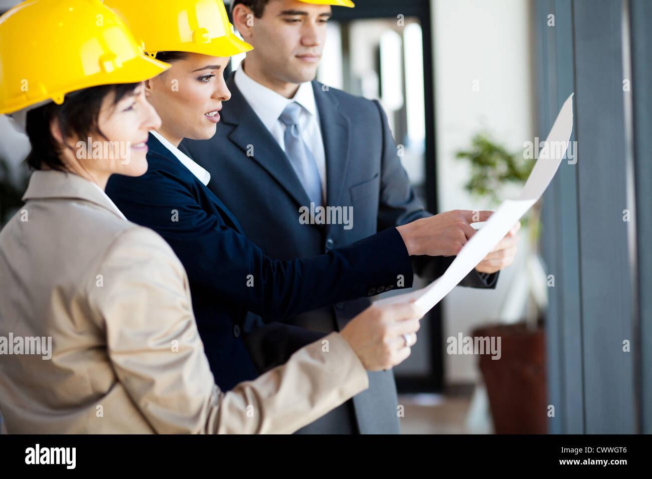 group of construction managers looking at blue print Stock Photo - Alamy