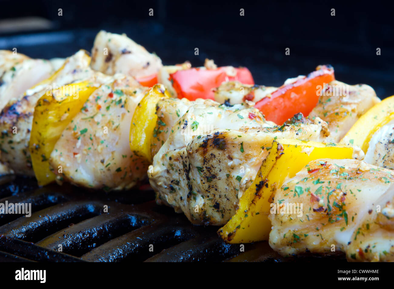chicken and pepper kebabs slowly cooking on the barbecue Stock Photo