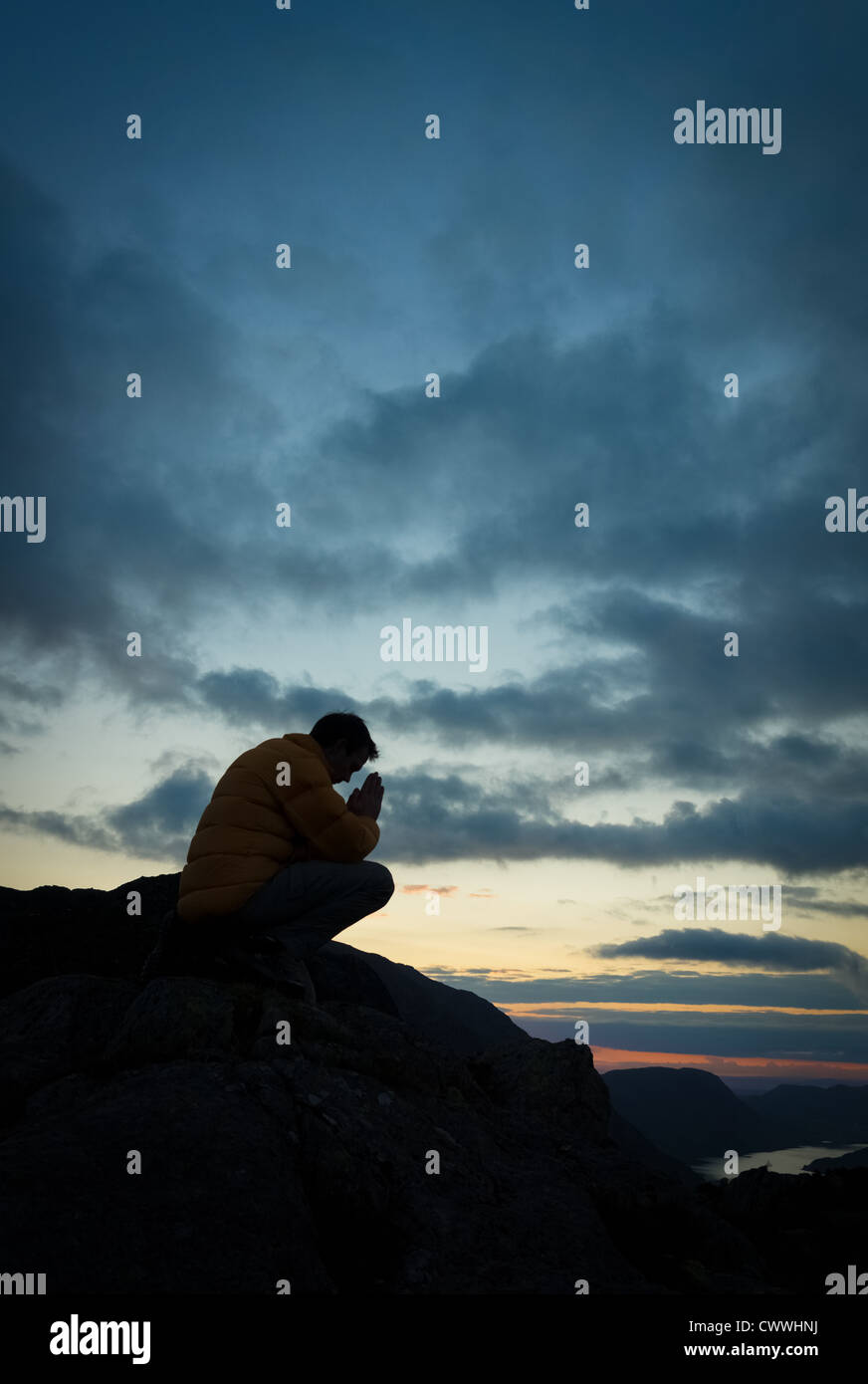 A man praying to God on the summit of a mountain Stock Photo - Alamy