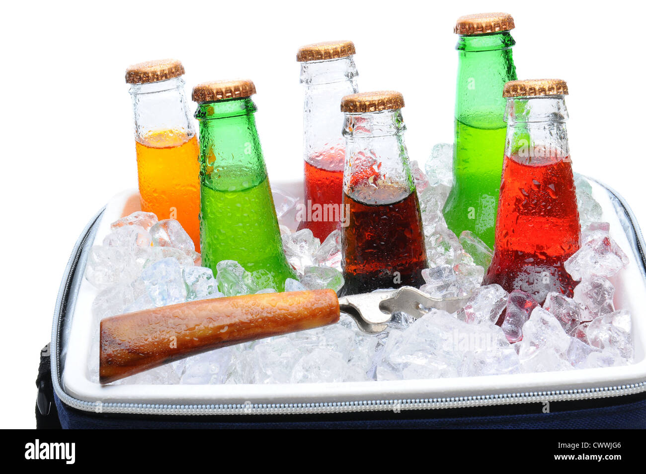 Assorted soda bottles in a cooler full of ice with bottle opener. Horizontal format over white. Stock Photo