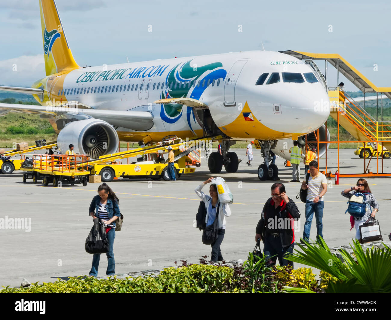 Gensan, Philippines - April 2, 2011: Travelers alight Cebu Pacific Air after landing in Gensan on a very hot day, while airport Stock Photo