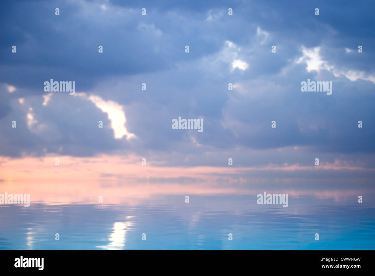 Blue sky at sunset. A sky of clouds reflected in a calm sea Stock Photo ...