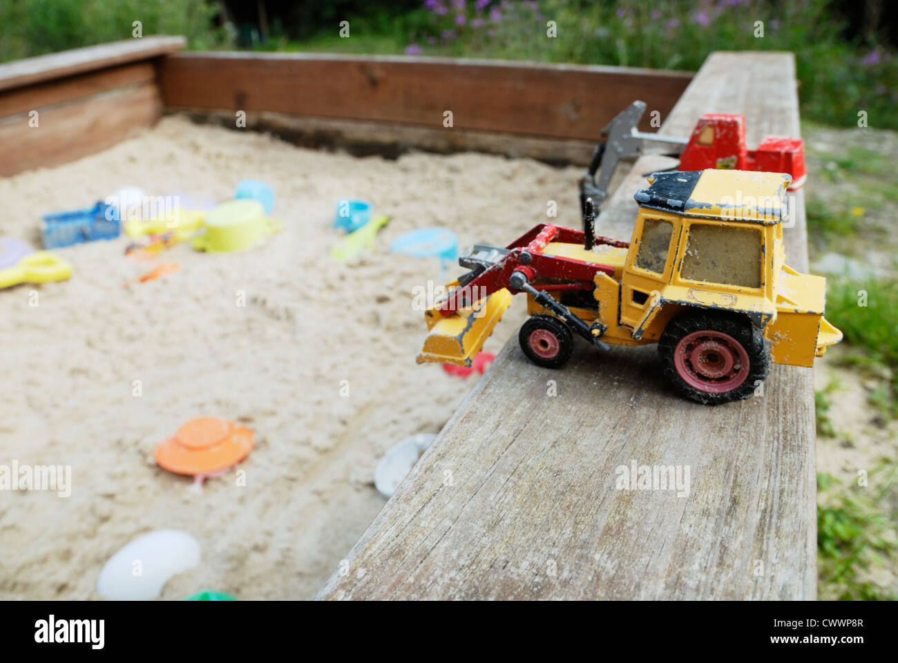 Toy diggers next to a sandpit, Wales. Stock Photo