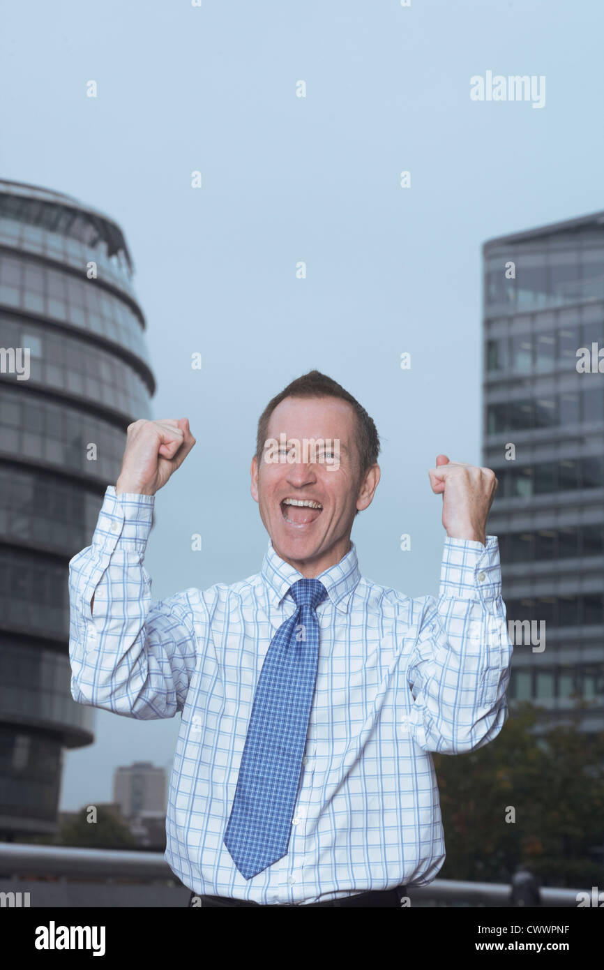 Businessman cheering outdoors Stock Photo