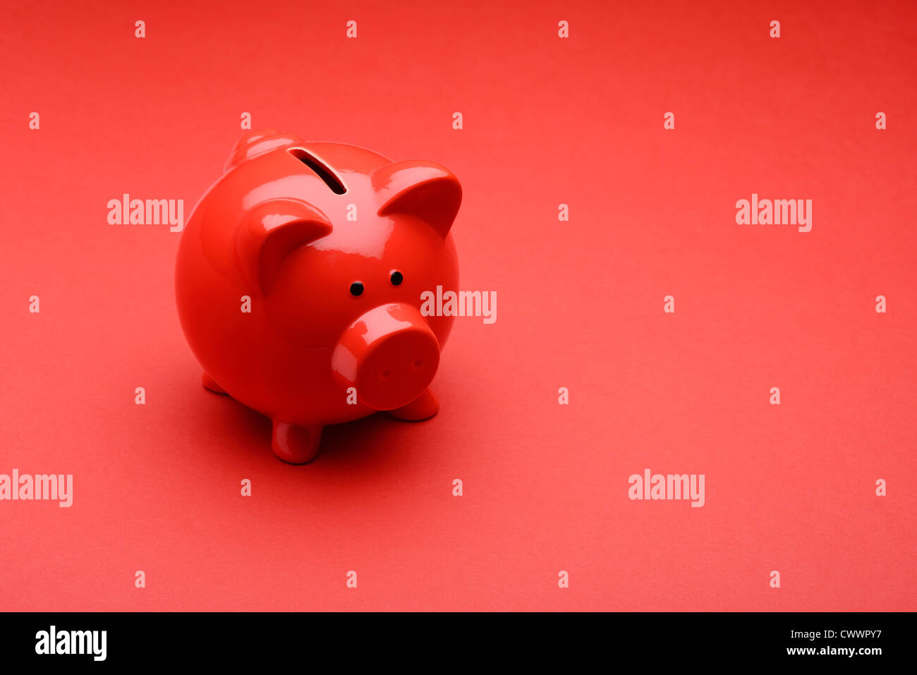 Red piggy bank on a red background Stock Photo