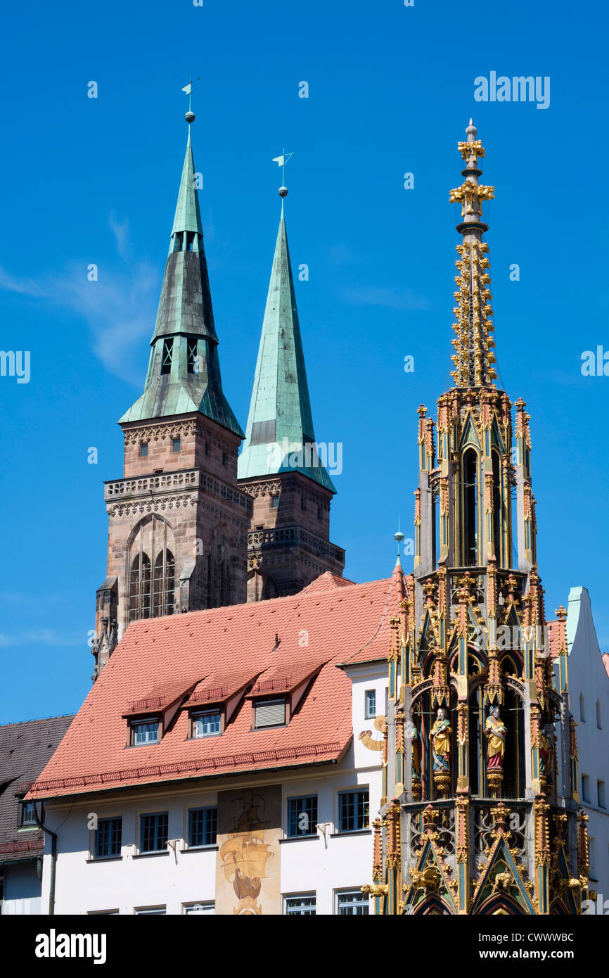 Schoene Brunnen (Beautiful Fountain) and spires of St Sebald's church in Nuremberg in Bavaria Germany Stock Photo