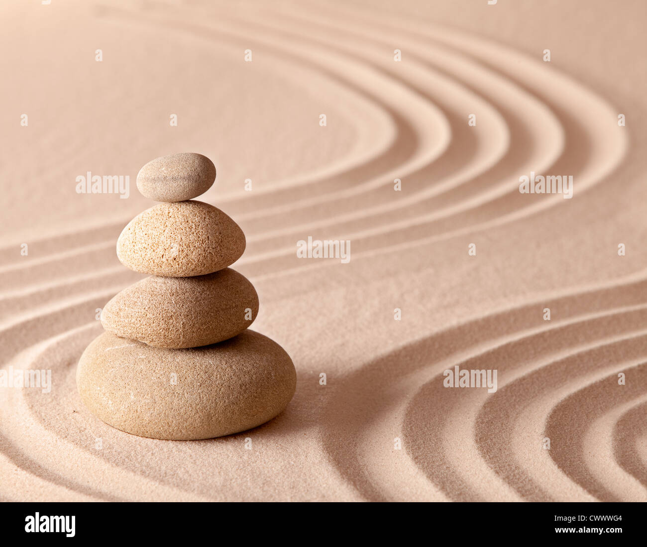zen garden stones in balance and pattern in sand Stock Photo