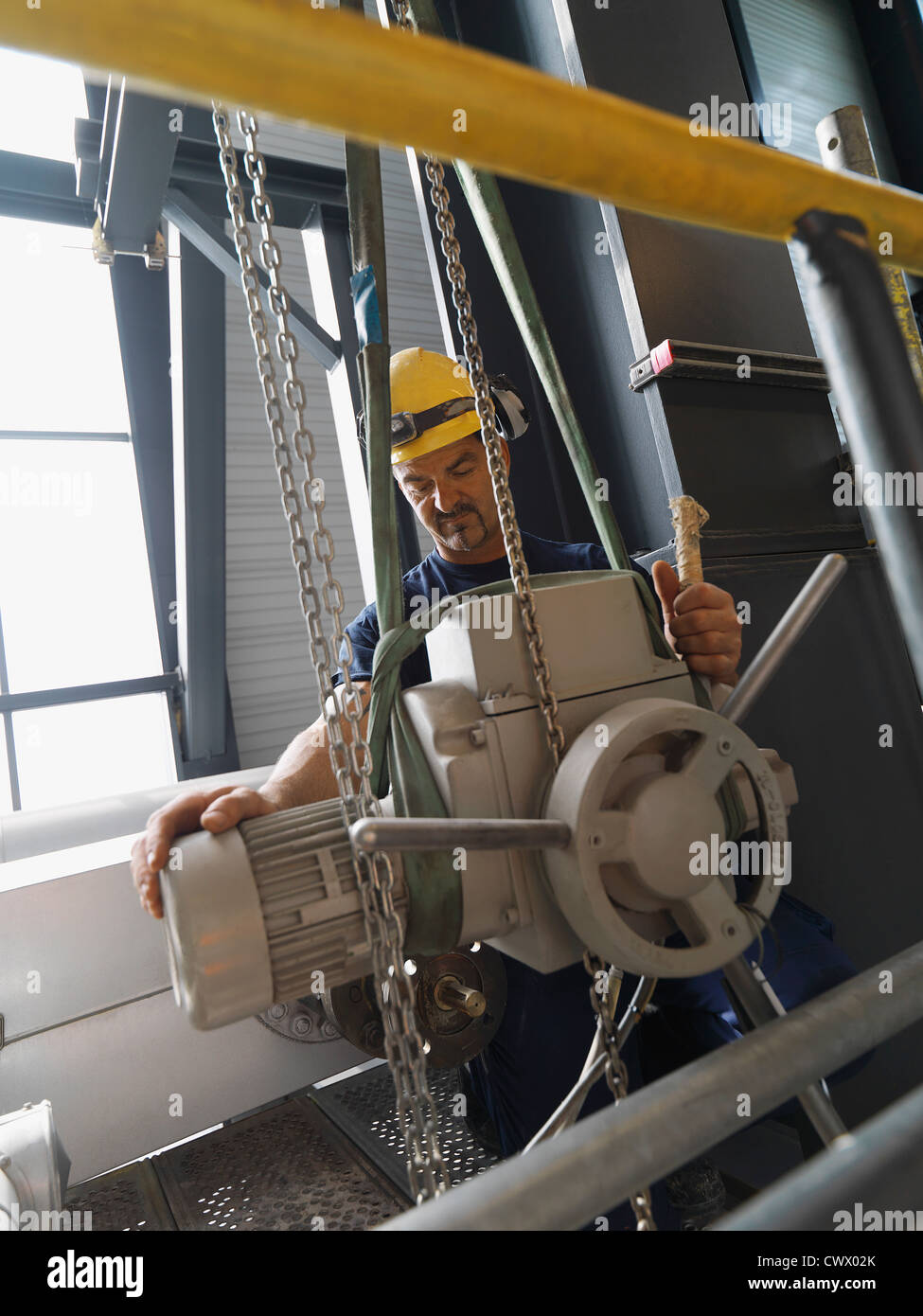 Worker operating machinery in factory Stock Photo