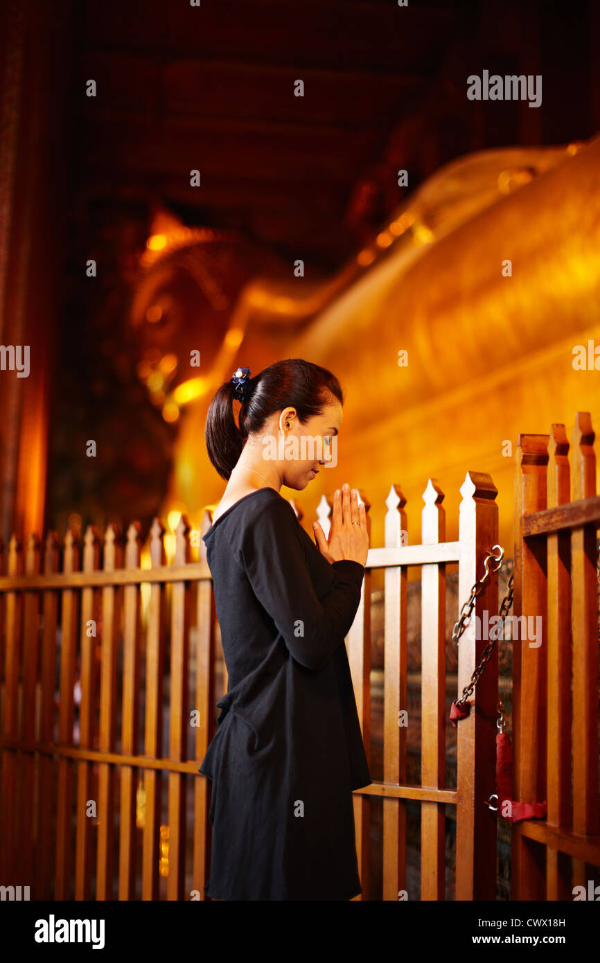 Woman praying at monument outdoors Stock Photo