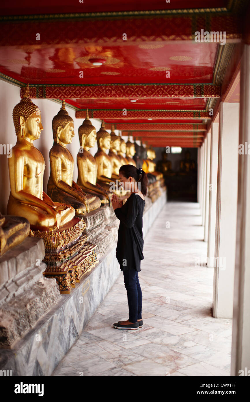 Woman praying in front of monument Stock Photo
