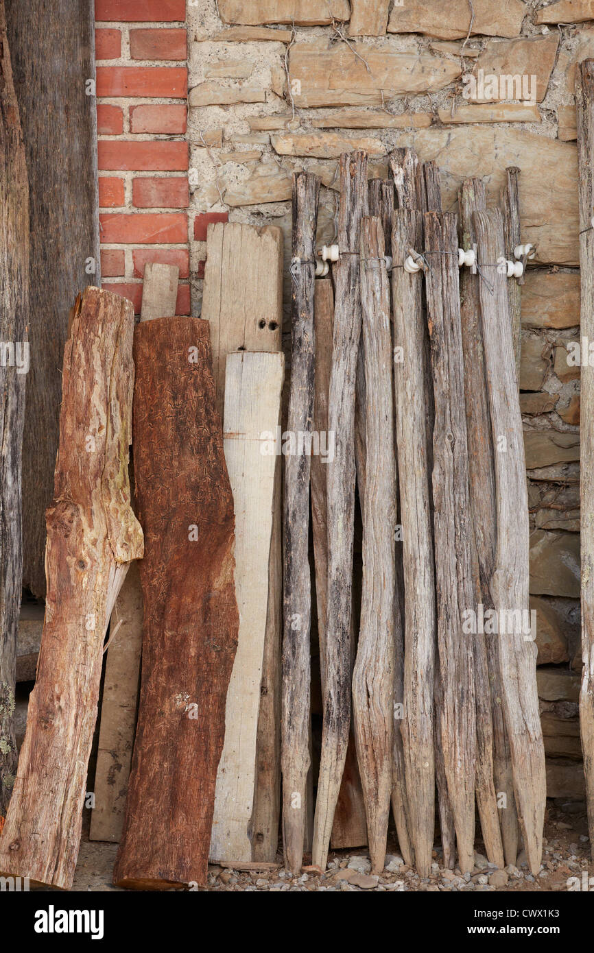 old wooden staves derelict rust wood slats brick stone wall green grass Stock Photo