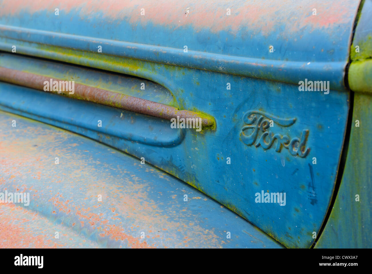Photo of the left side of an antique rusted out blue Ford Pickup Truck. Stock Photo